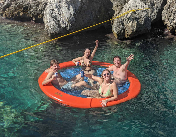 Group of people enjoying the Sunchill lake float water hammock