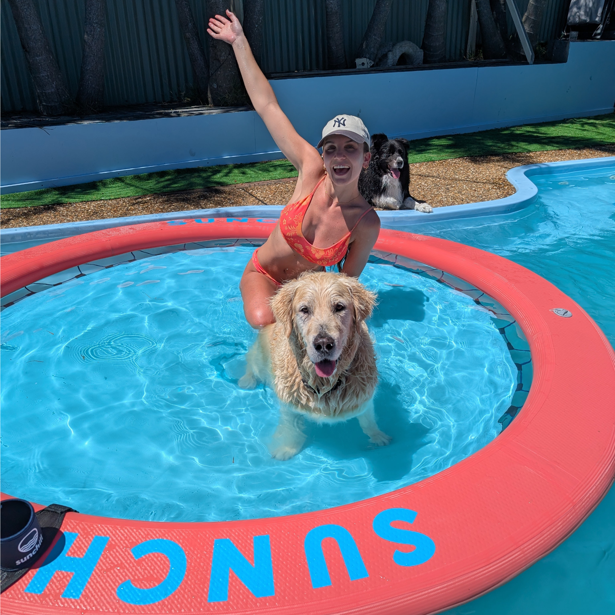 Woman and two dogs enjoying a Coral Sea Sunchill pool float.