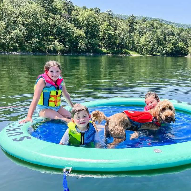 Kids and a dog enjoying the Seafoam Sunchill lake float.
