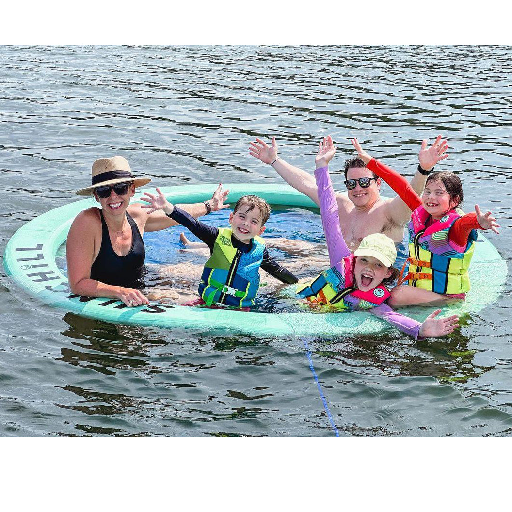 Family smiling together in the Seafoam Sunchill lake float.
